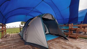 Una carpa sobre una cubierta de madera con dosel azul.