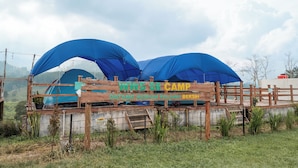 Un camping con toldos azules y un letrero de madera.