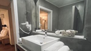 Un baño moderno con un lavamanos grande, un espejo y un perchero para toallas.