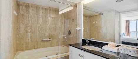Un baño moderno con bañera, lavabo y un espejo grande.