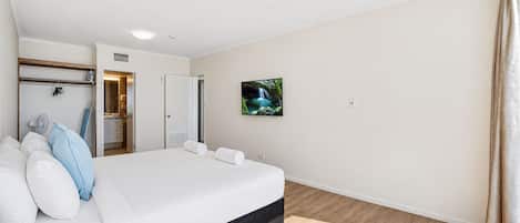 Une chambre d’hôtel comprenant un lit, une armoire, un téléviseur et une porte donnant accès à une salle de bain.