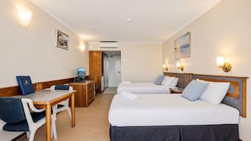 Une chambre d’hôtel avec deux lits, un bureau, une chaise et une petite table.
