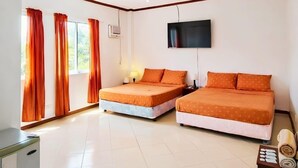 Habitación de hotel con dos camas, televisor, escritorio y ventana con cortinas.