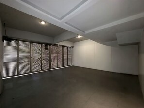 A spacious room with a high ceiling, recessed lighting, and a large window with horizontal blinds. - Modern, luxurious and centrally located minimalist house near the WTC (Del Valle Nte)