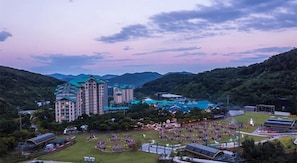 A hotel with multiple buildings, a large parking area, and a landscaped garden.