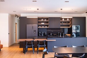 A modern kitchen with dark cabinetry, a central island, and pendant lighting. - Villa in Corfu with 7 bedrooms sleeps 14 (Corfu)