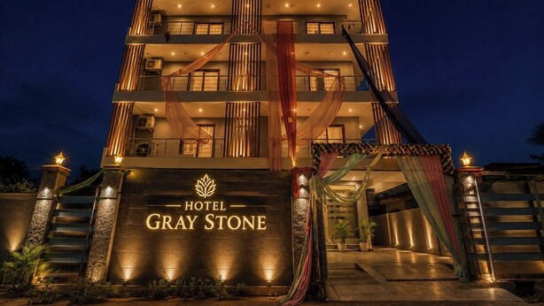A multi-story hotel with a prominent entrance, a staircase, and a sign reading 'HOTEL GRAY STONE.' - Hotel Gray Stone (Noida)