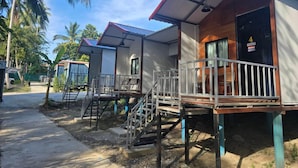A row of simple, single-story cabins with external stairs and a covered porch area. - Oasis Phamee (Ko Pha-ngan)