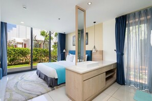 A modern hotel room with a large bed, a bathroom with a vanity, and a view of greenery outside. - Oceanami Long Hai Managed by Villa Owner (HO CHI MINH CITY)