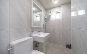 A modern bathroom with a toilet, sink, and shower.