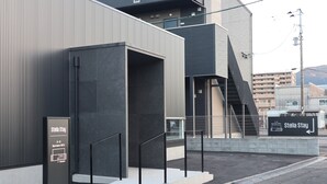 Un edificio moderno con una escalera, un cartel que dice 'Stella Stay' y vistas del entorno.