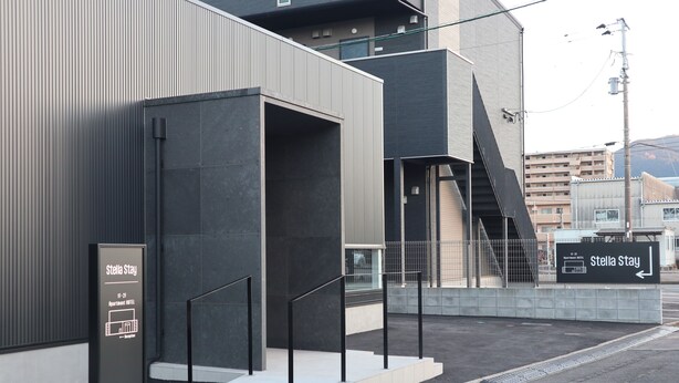 Un edificio moderno con una scala, un cartello con la scritta 'Stella Stay' e vista sulla zona circostante.