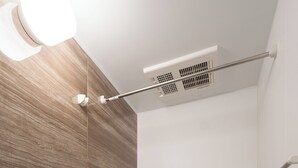 Un bagno moderno con una vasca, un soffione doccia, uno specchio e uno scaffale con articoli da toilette.