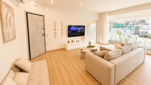 A modern living room with a sofa, a coffee table, and a TV. - Akrata Comfort Living (Krathi)