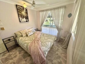 A bedroom with a bed, a ceiling fan, a window with curtains, and a wall-mounted artwork. - 5 Rocks Off-Grid 4WD Retreat (Stockyard)