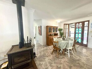 A dining area with a table set for four, a wooden cabinet, and a stove. - 5 Rocks Off-Grid 4WD Retreat (Stockyard)