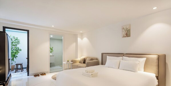 A modern hotel room with a large bed, a sofa, a small table, and a TV. - The Royal Sky Mame - Phu My Hung (Ho Chi Minh City)
