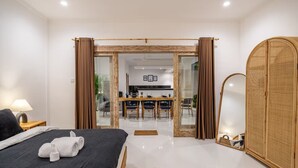 Quarto de hotel com cama, espelho, guarda-roupa e vista para a sala de jantar.