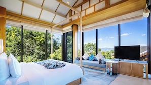 Un dormitorio moderno con una cama grande, televisión y vistas al exterior.