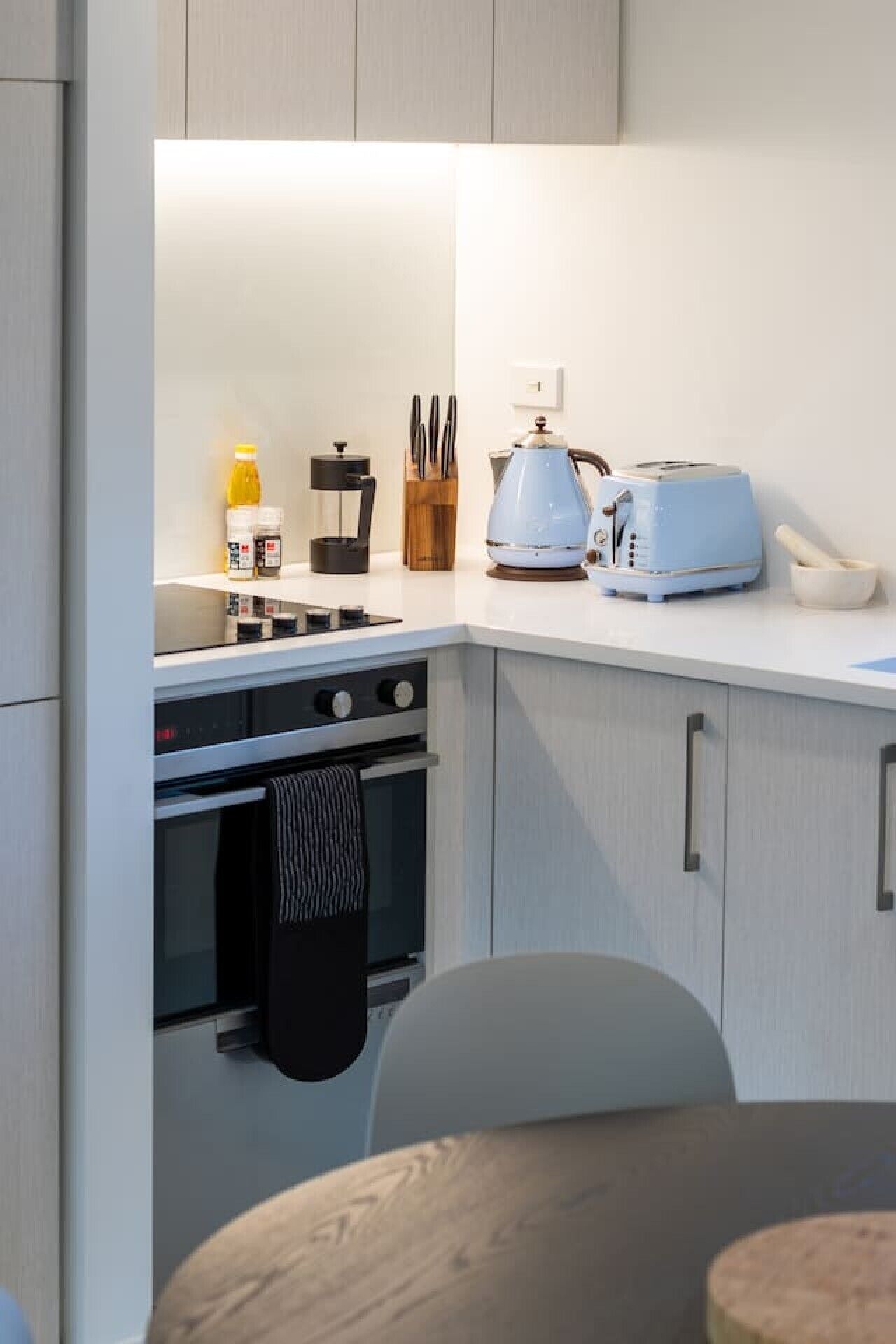 Een moderne keuken met een fornuis, broodrooster en koffiezetapparaat.