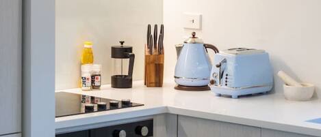 Een moderne keuken met een fornuis, broodrooster en koffiezetapparaat.