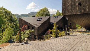 A modern building with a sloped roof, a staircase, and a view of the surrounding landscape. - Luxury Apartment in Szczyrk | Mountain Views, Air Conditioning (Szczyrk)