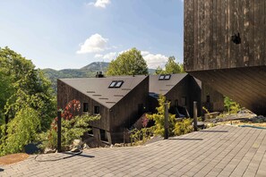 Ein modernes Gebäude mit geneigtem Dach, einer Treppe und Blick auf die umliegende Landschaft.