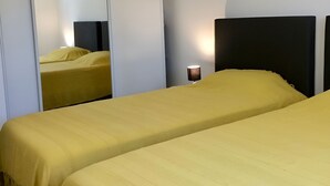 A hotel room with two beds, a mirror, a nightstand with a lamp, and a wardrobe. - Beautiful, comfortable villa (Prunelli-di-Fiumorbo)