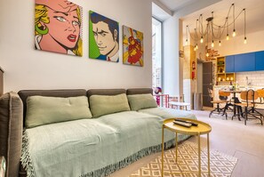 Ein modernes Wohnzimmer mit einer Couch, einem Couchtisch und einem Essbereich mit Stühlen und einem Tisch.