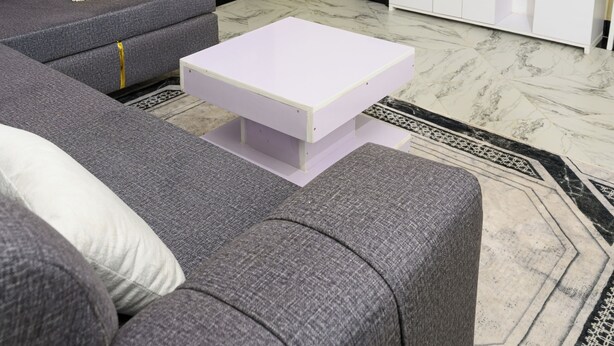 Ein Wohnzimmer mit Sofa, Couchtisch, Fernseher und Wasserspender.