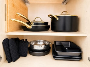 A kitchen with black cookware, including pots and pans, and black oven mitts on the shelf. - Private 1BR Apt, 2BD 1BA, Sleeps 5, Clean & Reliable, Near NYC (Scotch Plains)