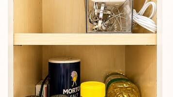 Un pensile da cucina con un elettrodomestico bianco, sale, pepe, Morton salt e un barattolo di sale e pepe al limone.