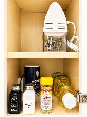 A kitchen cabinet with a white appliance, salt, pepper, Morton salt, and a jar of lemon pepper. - Private 1BR Apt, 2BD 1BA, Sleeps 5, Clean & Reliable, Near NYC (Scotch Plains)