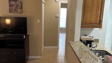 Une cuisine dotée d’un plan de travail en granit, d’un four encastré et d’une armoire en bois.