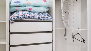 Ein begehbarer Kleiderschrank mit Kleiderstange, Regalen und Schubladen.