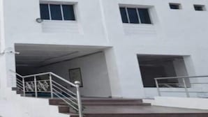 Un immeuble à plusieurs étages, doté d’une façade blanche, de nombreuses fenêtres et d’un escalier menant à l’entrée.