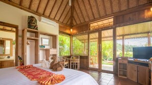 A bedroom with a bed, a television, a desk, and a chair. - Bali Sawah Indah  (Tampaksiring)