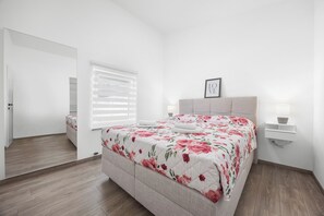 A bedroom with a bed, a bedside table, a nightstand, a window with blinds, and a door. - Villa Emma by Istrabook (Pula)