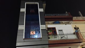 Ein mehrstöckiges Gebäude mit einem auffälligen, vertikalen Fenster und einem Balkon mit Geländern.