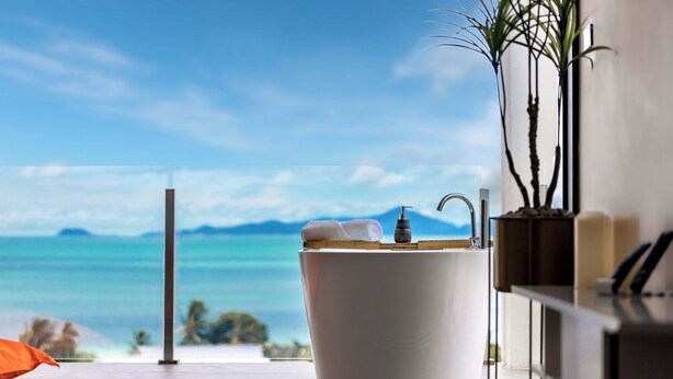 A bathroom with a large bathtub, a view of the sea, and a potted plant. - Luxury Sunset House Home Gym Cinema (Bophut)