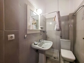 A bathroom with a sink, mirror, toilet, and shower curtain. - 104 - EVROSTAR Studio by SDR (Paralia)