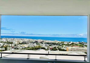 A balcony with a view of a coastal cityscape, buildings, and the sea. - PERLE INSULAIRE - T2 COSY & SEA VIEW - Saint-Denis (Reunion Island) (Saint-Denis)