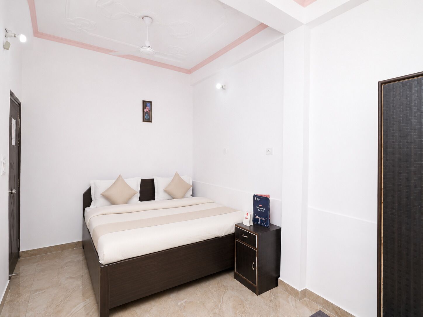A bedroom with a bed, bedside table, and a door.