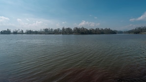 A calm lake with a distant tree line under a clear sky. - TB Villa Resort By ARBA (Pangalengan)