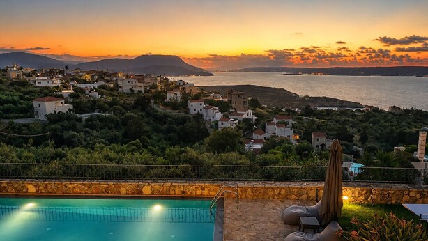 A pool with a stone deck, a cactus, and a view of a coastal town at sunset. - Hidden Oasis Amazing Seaview - Erato 1BD 1BA 4PL (Apokoronas)