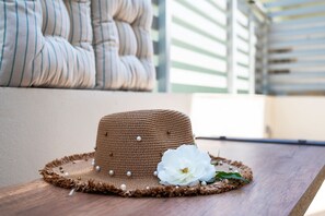 A straw hat with pearls and a white flower on a wooden table. - Hilltop Apartment in Monte Smith Rhodes (Rhodes)