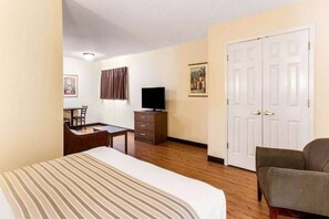 A hotel room with a bed, a desk with a chair, a television, a wardrobe, and a sofa. - 1 Queen Bed|Non-Smoking, Kitchen (Myrtle Beach SC)