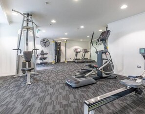 Ein Fitnessstudio mit Laufbändern, Crosstrainern und Gewichten.