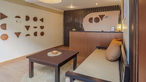 A modern room with a sofa, a table, and a decorative wall with geometric shapes. - Cove Premisol (Denpasar)