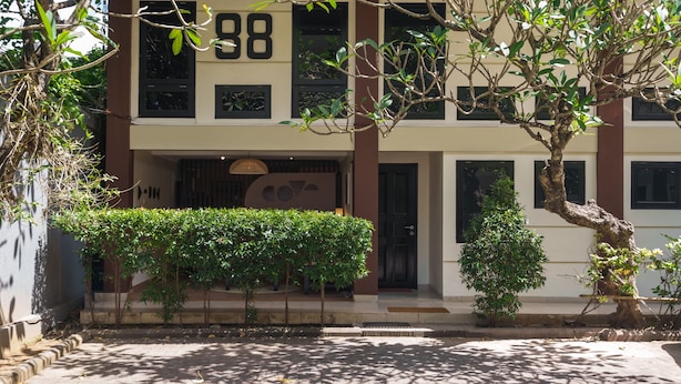 A two-story building with a number '88' on the facade, a covered entrance, and a small tree in front. - Cove Premisol (Denpasar)